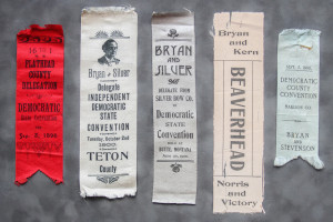 A close up of several old ribbons with political information.