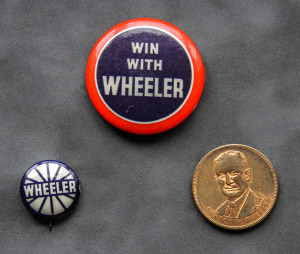A close up of three buttons with the words " win with wheeler ".