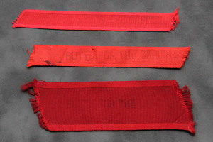 Three red ribbons are shown on a gray surface.