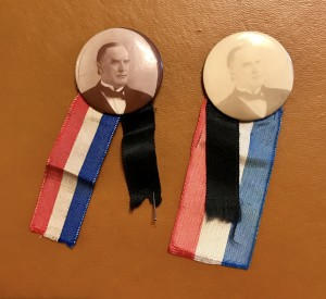 Two buttons with a ribbon and a picture of president mckinley.