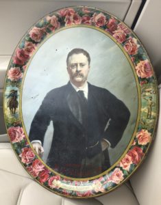 A painting of theodore roosevelt on the wall.