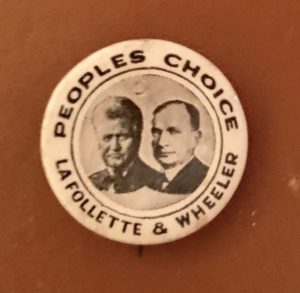A button with two men 's faces on it.